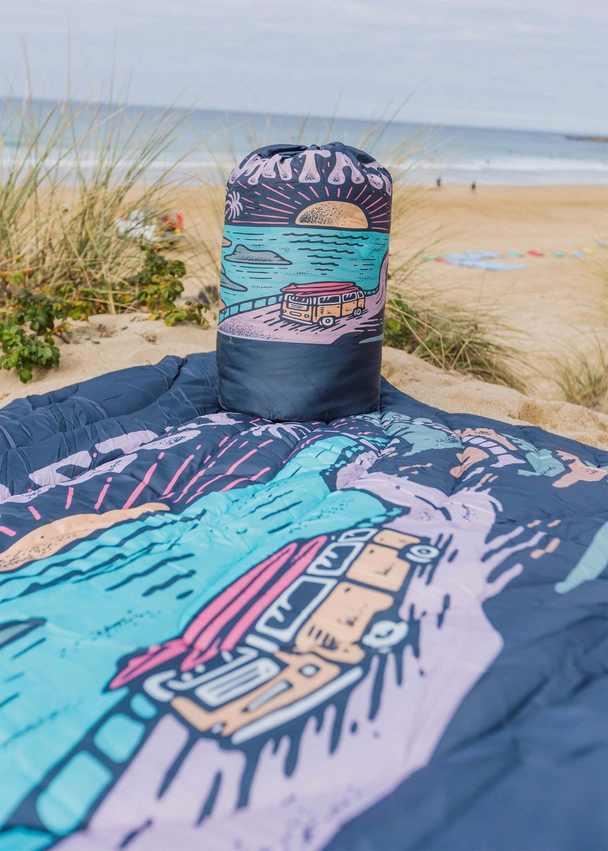 Colourful blanket with beach scene design on a sandy background