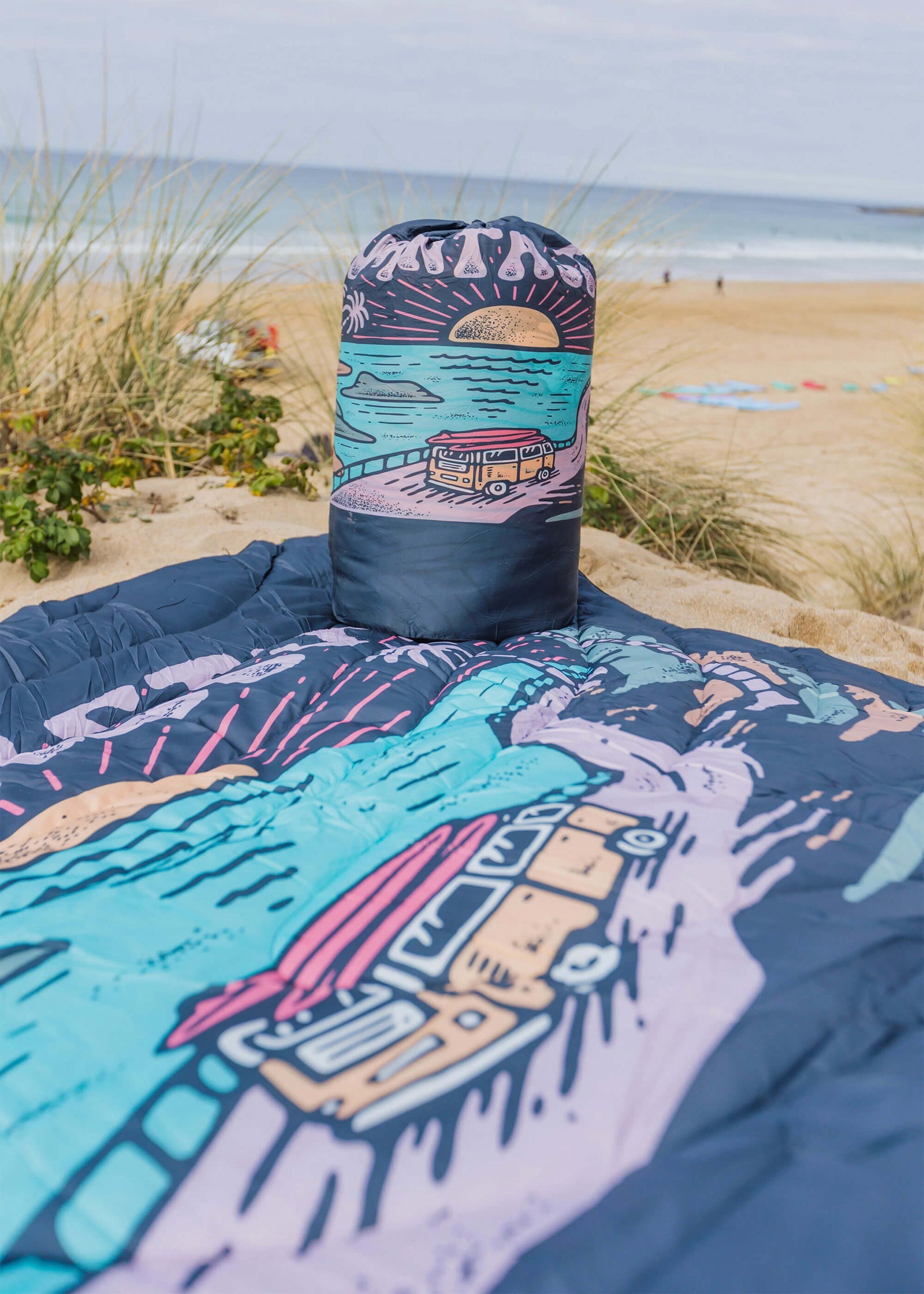 Colourful blanket with beach scene design on a sandy background