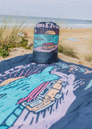 Colourful blanket with beach scene design on a sandy background